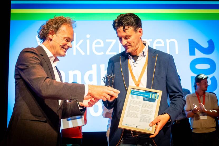 Rob Broekman van de Nederlandse Voedsel- en Warenautoriteit neemt de prijs als Festivalfavoriet in ontvangst: een verbronsd beeldje van 'Art for more'