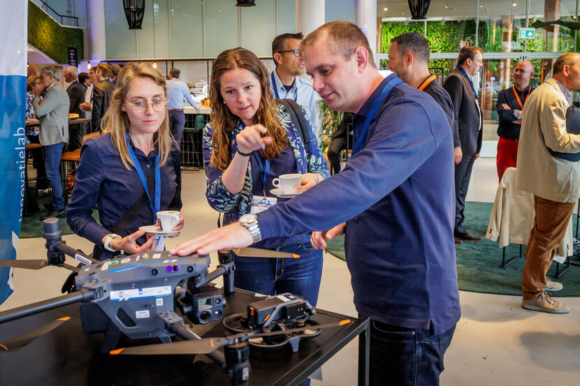 Sfeerbeeld Toezichtfestival 2024 man toont drone aan 2 vrouwelijke bezoekers